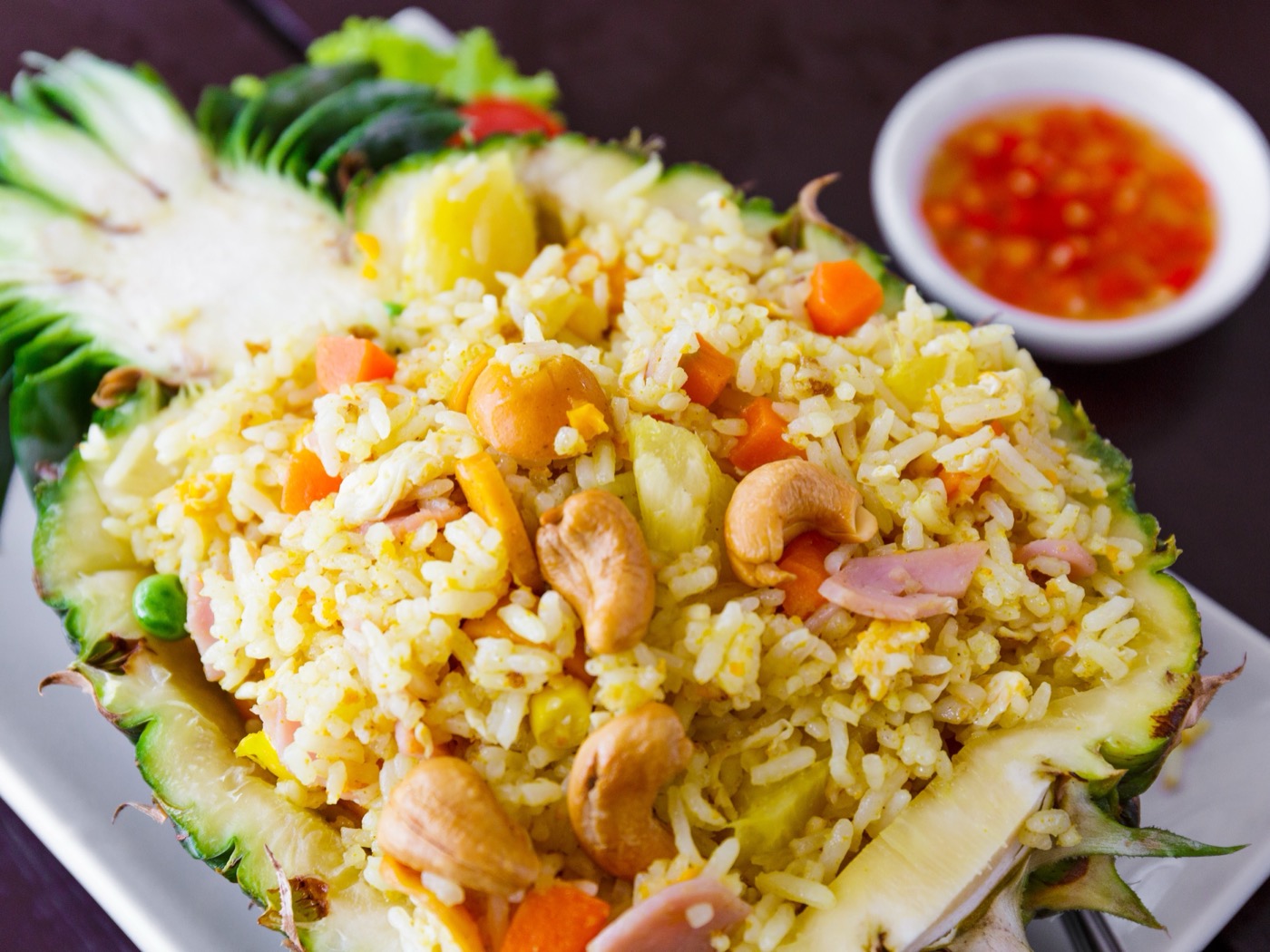 Pineapple fried rice with cashews served in a pineapple boat